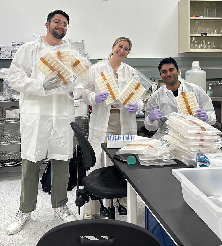 upward-81-janus-uconn-team-spx31 Max Landolina, Maddie Picket, and Jared Lawrence (left to right) from the University of Connecticut prepare the team's investigation for launch on SpaceX CRS-31.