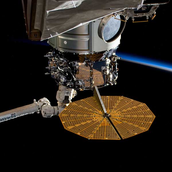 The Northrup Grumman Cygnus space freighter is pictured in the grip of the Canadarm2 robotic in April 2023.
