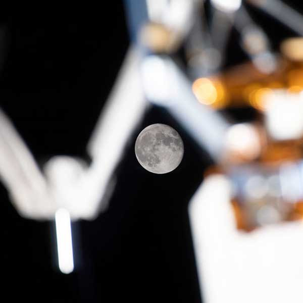 September's full Moon, the Harvest Moon, is photographed from the International Space Station, perfectly placed in between exterior station hardware.