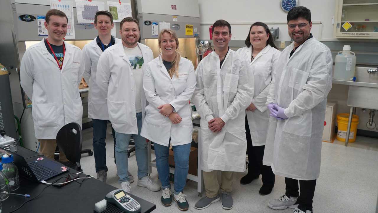 upward-82-encapsulate-team-issnl From left: Mark Reeves, Zach Jacobs, Kendall Nelson, Taylor Stallings-Pinnick (Space Tango), John Catechis, Erica Bumgardner (ISS National Lab), and Armin Rad (Encapsulate) at a Kennedy Space Center lab, preparing flight samples for SpaceX CRS-30.