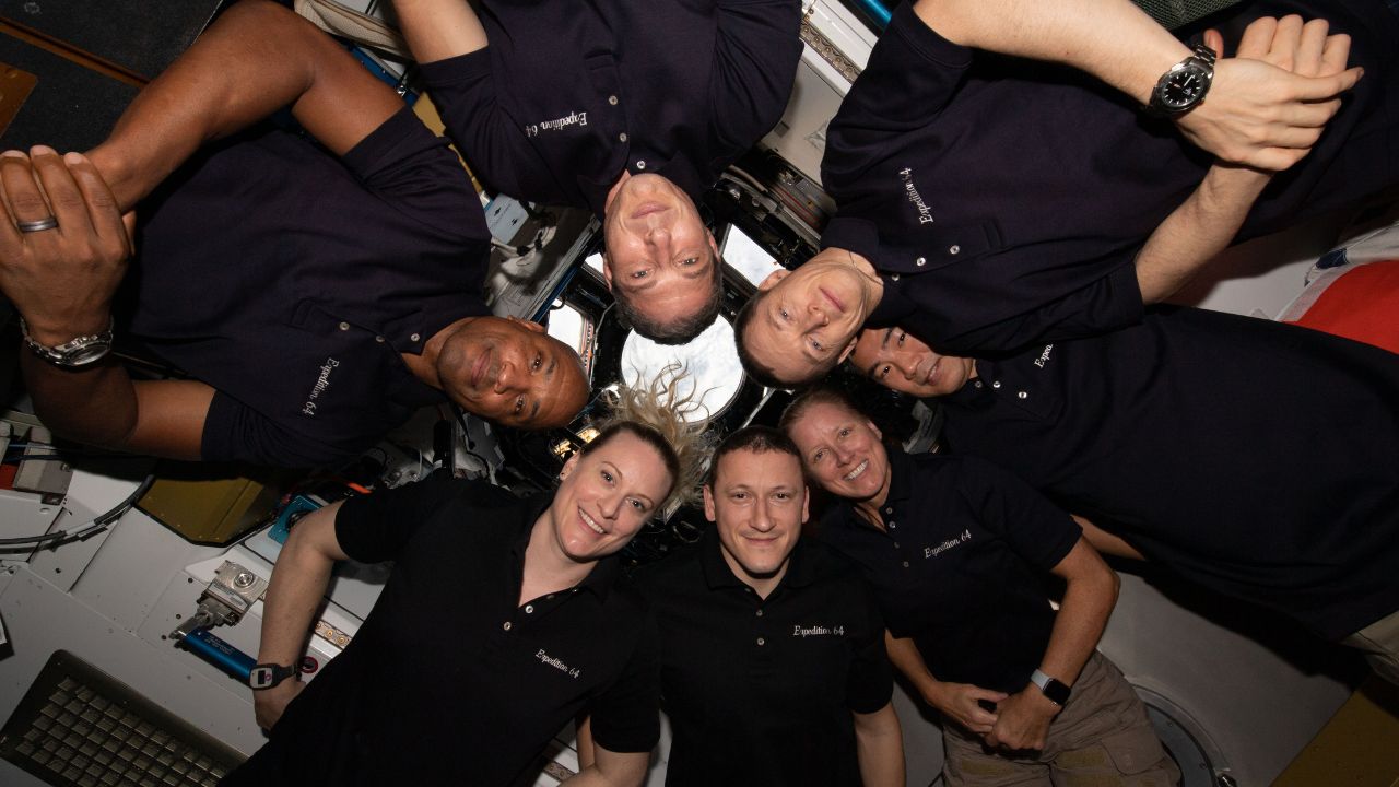 The seven-member Expedition 64 crew gathers together for a New Year's Day portrait inside the International Space Station's "window to the world," the cupola.