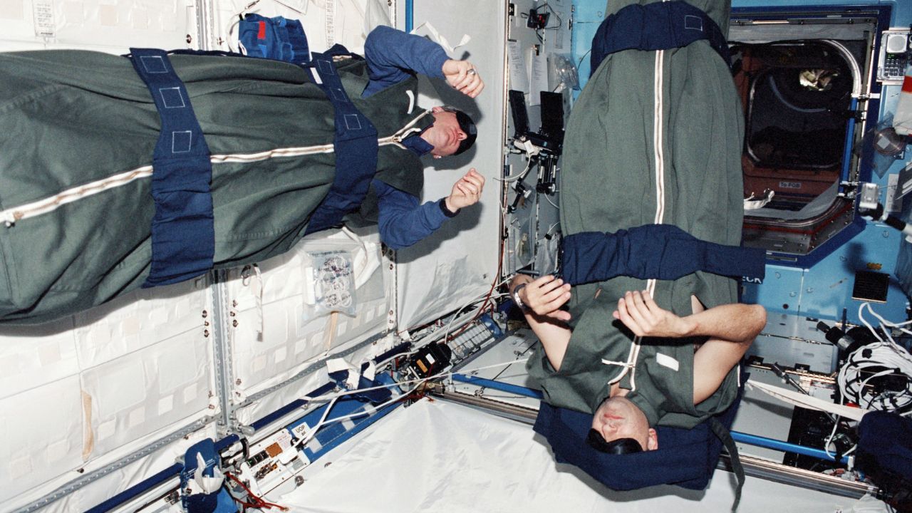 Sleep-1280x720 NASA astronauts Thomas D. Jones and Mark L. Polansky, mission specialists, photographed during their sleep shift in the Destiny module on the ISS in 2001.