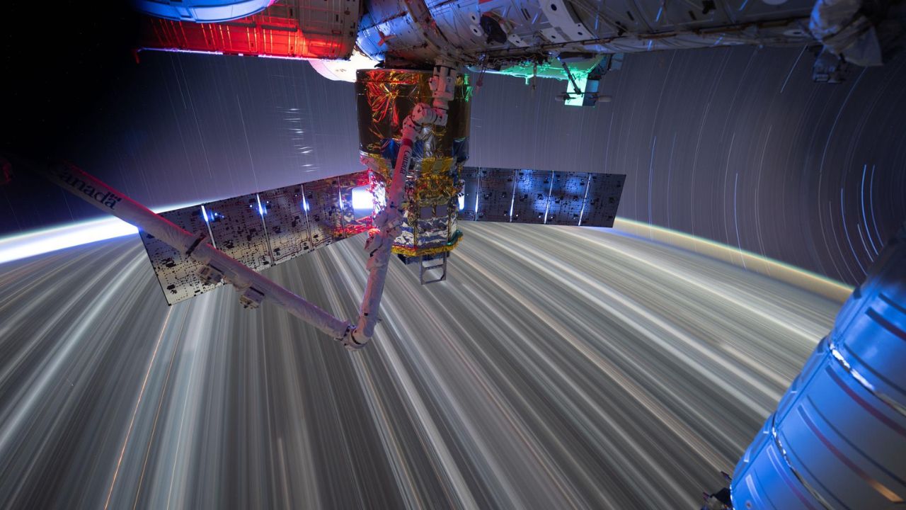 Star trails and city lights streak by as the International Space Station orbits Earth