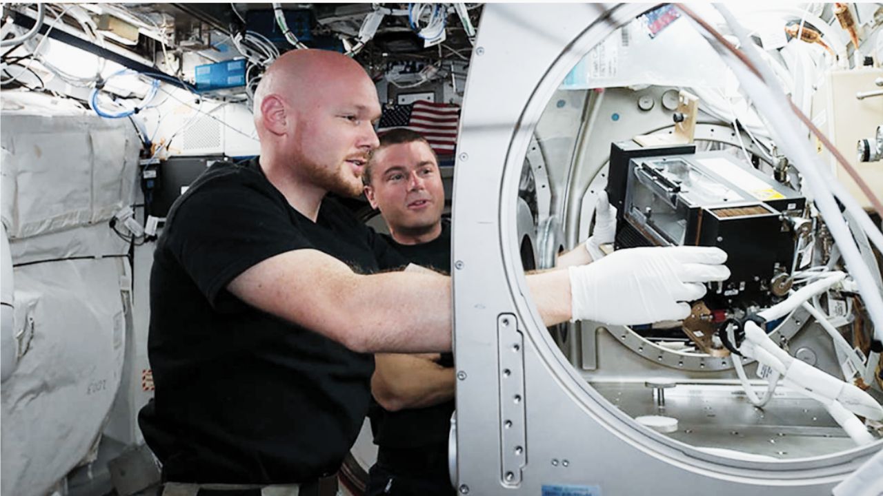 ESA astronaut Alexander Gerst and NASA astronaut Reid Wiseman work on a combustion experiment on the ISS, one of many projects funded by the U.S. National Science Foundation.